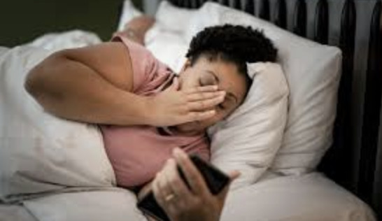 woman feeling sick scrolling her phone looking bored and fatigued