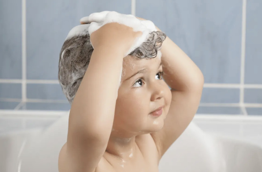 Child shampoo hair in bath